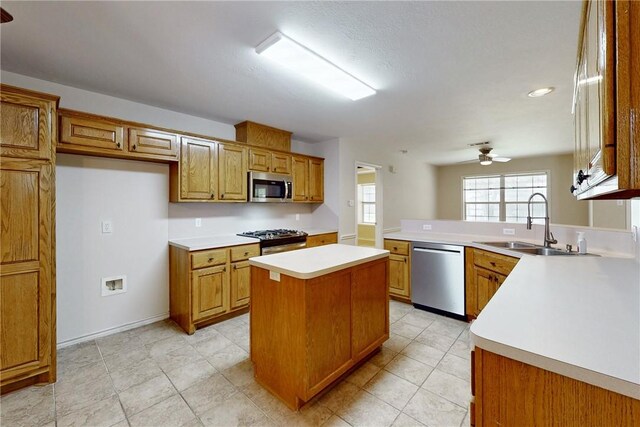2600 Greenberry Cir, College Station, TX 77845 - kitchen featuring appliances with stainless steel finishes, brown cabinetry, a sink, ceiling fan, and light countertops