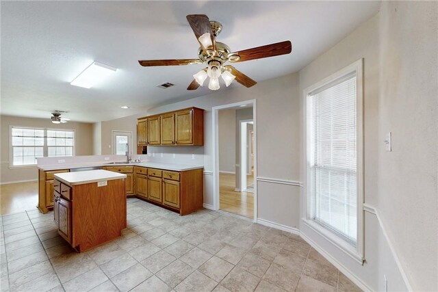 2600 Greenberry Cir, College Station, TX 77845 - kitchen featuring brown cabinets, light countertops, ceiling fan, and a center island