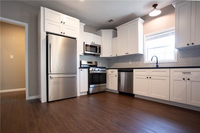 kitchen featuring white cabinets, stainless steel appliances, and dark hardwood / wood-style floors