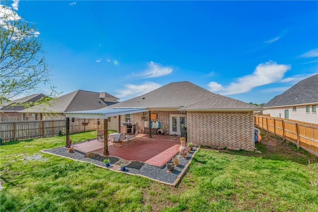 back of house with a lawn and a patio