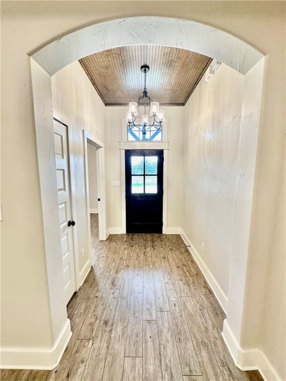 doorway with wooden ceiling, a chandelier, and hardwood / wood-style flooring