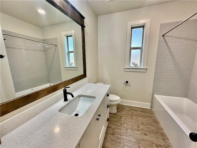 full bathroom with wood-type flooring, vanity, toilet, and tiled shower / bath combo