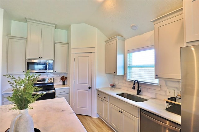 172 Pleasant Path, Somerville, TX 77879 - kitchen featuring stainless steel appliances, a sink, light countertops, backsplash, and lofted ceiling