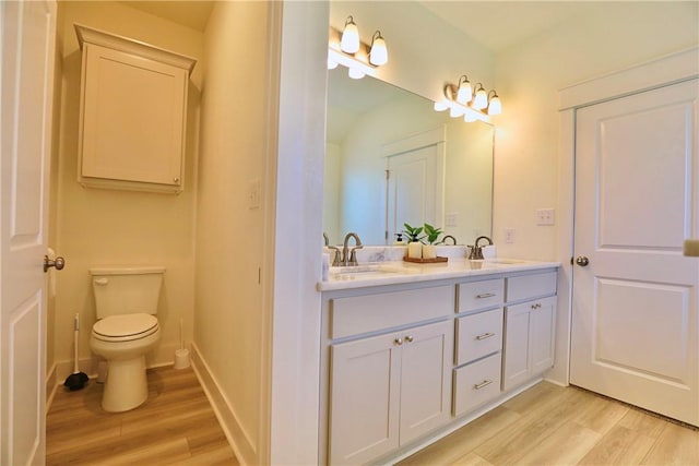 172 Pleasant Path, Somerville, TX 77879 - bathroom with wood finished floors, double vanity, toilet, and baseboards
