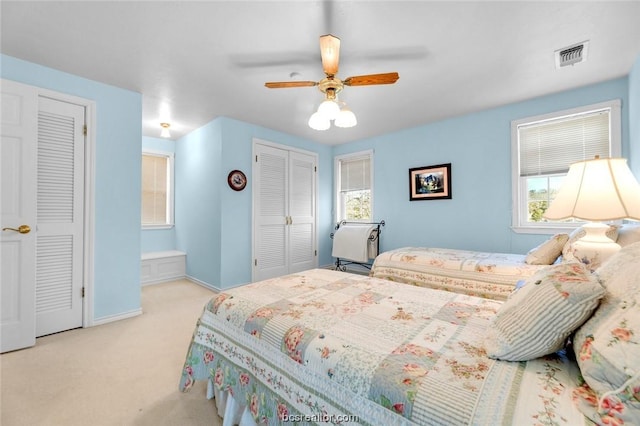 carpeted bedroom featuring two closets and ceiling fan