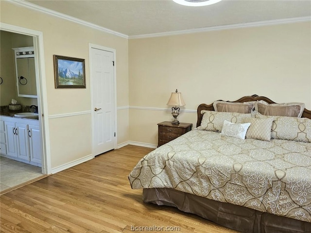 bedroom with light hardwood / wood-style flooring, ensuite bath, crown molding, and sink