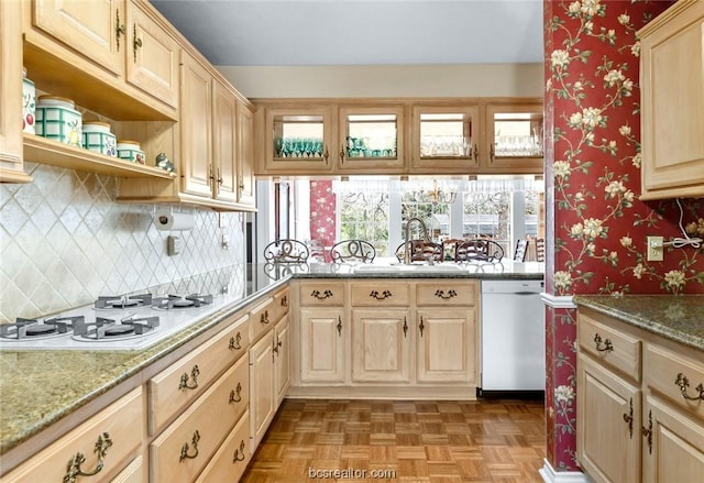 kitchen featuring light stone counters, dishwashing machine, white gas cooktop, light parquet floors, and sink