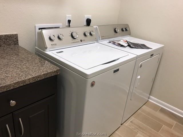 laundry room with washer and dryer and cabinets