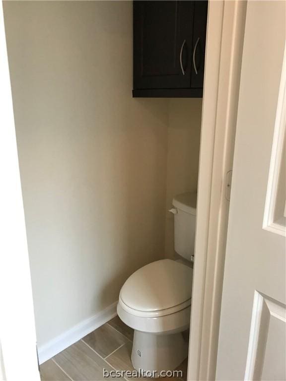 bathroom featuring hardwood / wood-style flooring and toilet