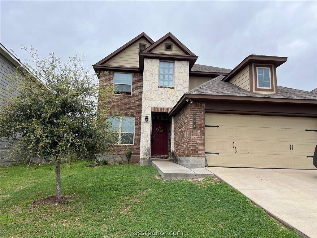 view of front of house featuring a garage and a front lawn