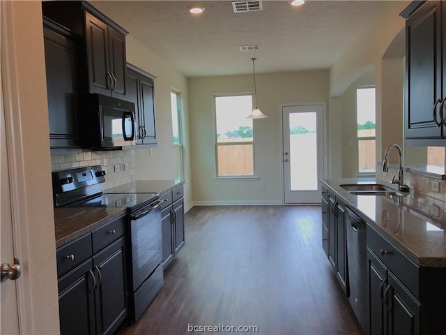 kitchen with pendant lighting, backsplash, black appliances, sink, and dark hardwood / wood-style flooring