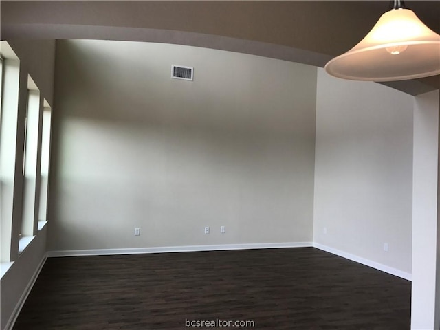 empty room with dark hardwood / wood-style flooring