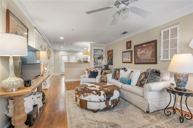 living room featuring ceiling fan, crown molding, and light hardwood / wood-style floors