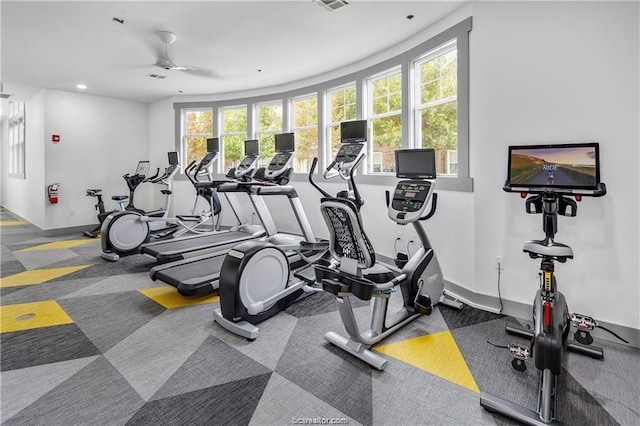 exercise room with ceiling fan, carpet, and plenty of natural light