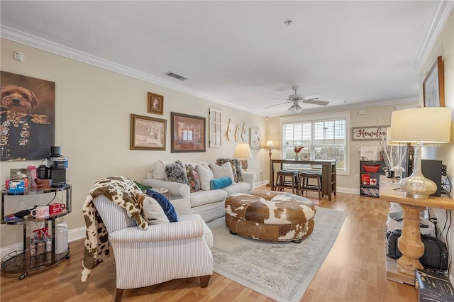 living room with ceiling fan, ornamental molding, and hardwood / wood-style floors