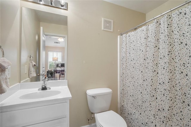 bathroom with toilet, vanity, and curtained shower