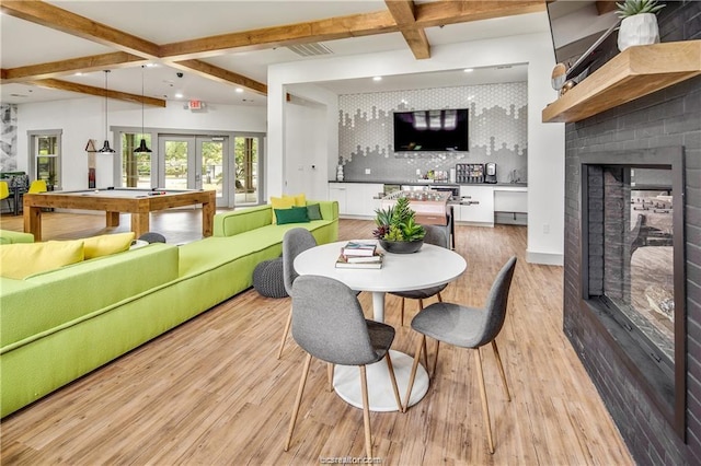 dining area with billiards, beam ceiling, light wood-type flooring, bar, and french doors