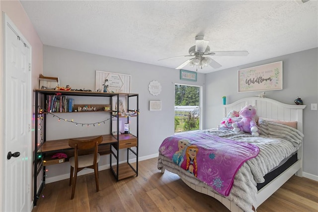 2092 Fm 1486th Rd, Anderson, TX 77830 - bedroom featuring wood finished floors, a textured ceiling, baseboards, and ceiling fan