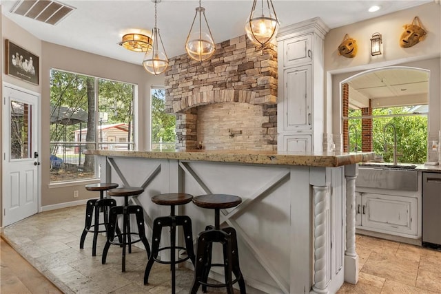 2092 Fm 1486th Rd, Anderson, TX 77830 - kitchen with light stone counters, a sink, dishwasher, a kitchen bar, and visible vents