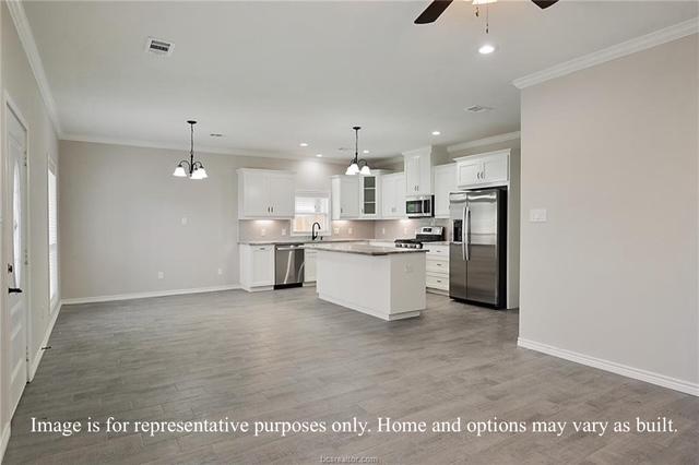 kitchen with wood finished floors, visible vents, ornamental molding, stainless steel appliances, and a center island