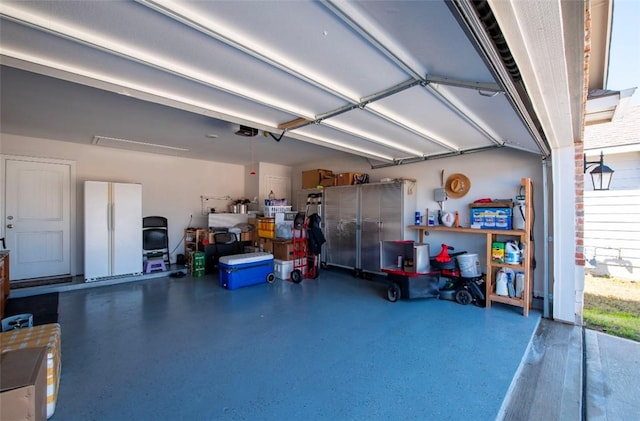 garage with a garage door opener and freestanding refrigerator