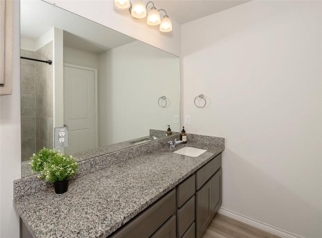 bathroom with wood finished floors, vanity, and baseboards