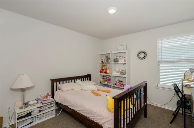 bedroom with dark carpet and baseboards