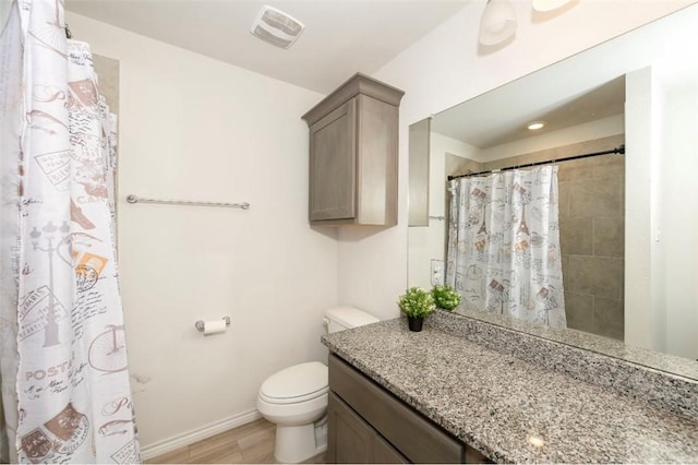 bathroom featuring visible vents, toilet, a tile shower, vanity, and baseboards