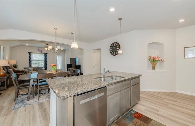 kitchen with decorative light fixtures, lofted ceiling, open floor plan, a sink, and dishwasher