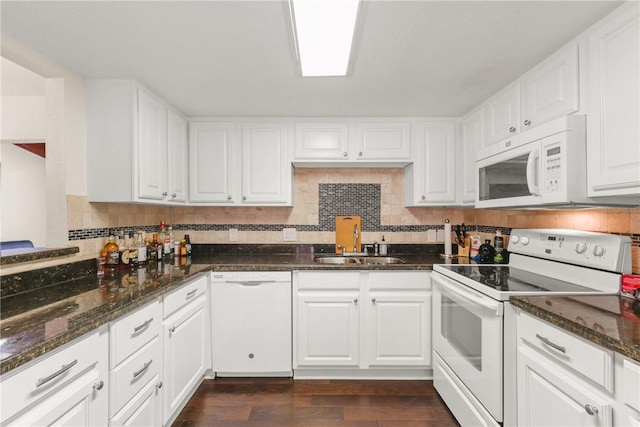 kitchen with a sink, decorative backsplash, white appliances, white cabinets, and dark wood-style floors
