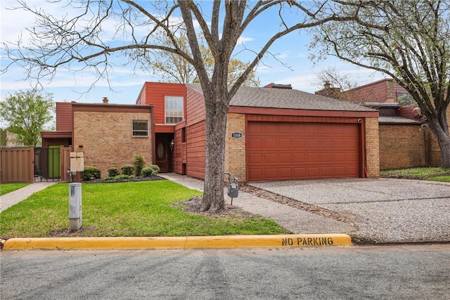 view of front of house with a front lawn, fence, brick siding, an attached garage, and aphalt driveway