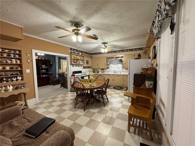 dining space featuring a textured ceiling, ceiling fan, crown molding, and sink