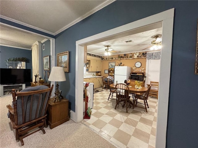 dining area featuring ceiling fan, a textured ceiling, and ornamental molding