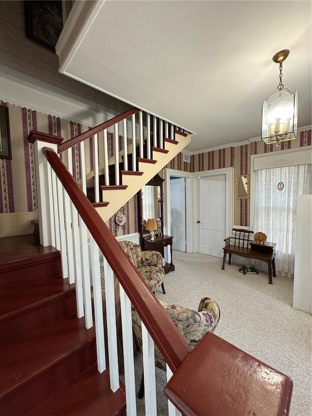 stairs with carpet and a notable chandelier