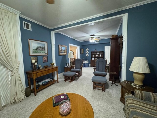 carpeted living room with crown molding and ceiling fan