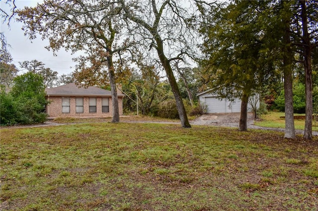 view of yard featuring a garage and an outbuilding