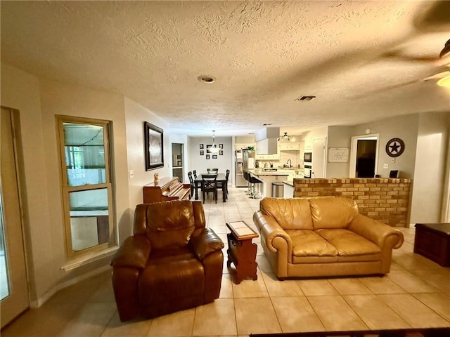 65 Navarro Dr, Hilltop Lakes, TX 77871 - living room with light tile patterned flooring, a textured ceiling, and baseboards