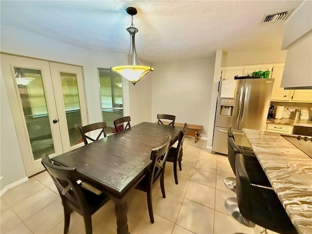 65 Navarro Dr, Hilltop Lakes, TX 77871 - dining room with light tile patterned floors, french doors, baseboards, and a textured ceiling