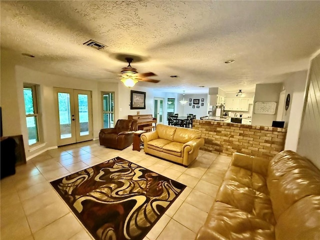 65 Navarro Dr, Hilltop Lakes, TX 77871 - living room featuring light tile patterned flooring, ceiling fan, french doors, and a textured ceiling