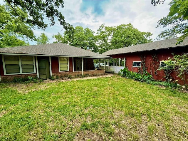65 Navarro Dr, Hilltop Lakes, TX 77871 - back of house featuring a lawn and brick siding