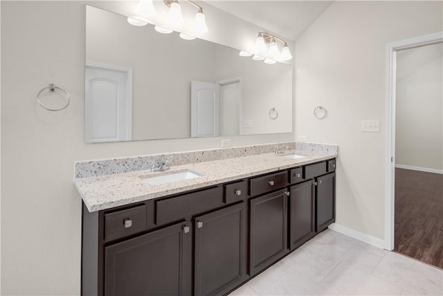 bathroom featuring vanity, vaulted ceiling, and tile patterned floors