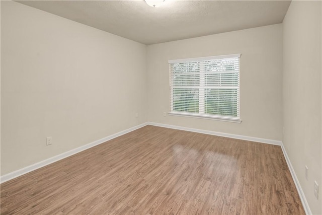 unfurnished room with hardwood / wood-style flooring