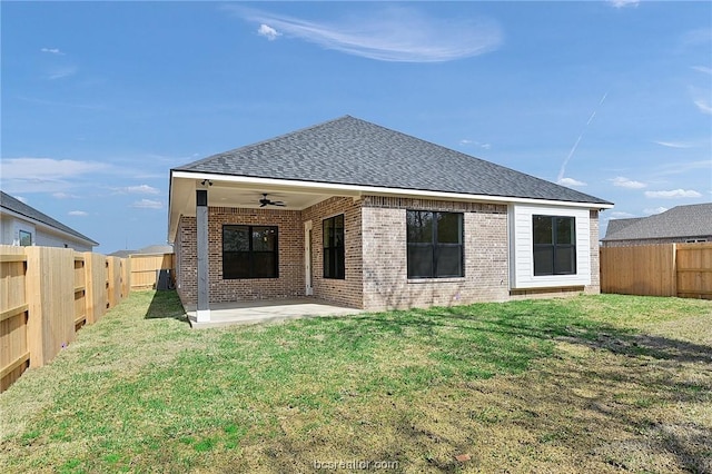 back of property with a lawn, ceiling fan, and a patio area