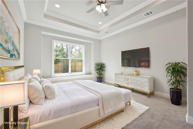 bedroom with a tray ceiling, ceiling fan, crown molding, and light colored carpet