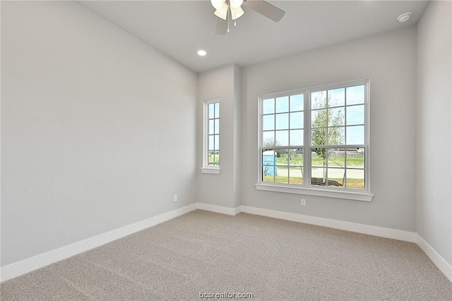 carpeted spare room with ceiling fan