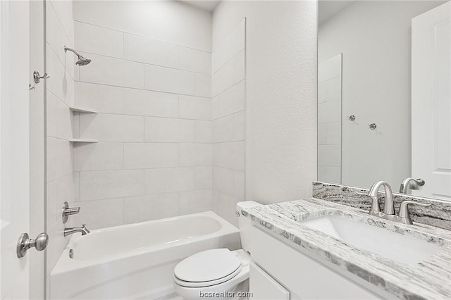 full bathroom with vanity, tiled shower / bath combo, and toilet