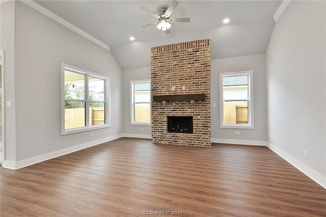 unfurnished living room with lofted ceiling, crown molding, ceiling fan, dark hardwood / wood-style floors, and a fireplace