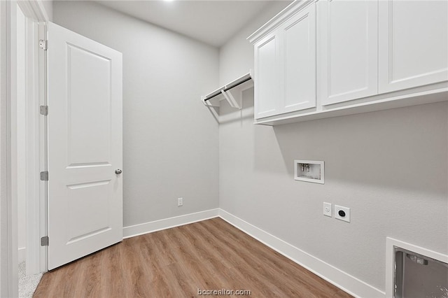 washroom with electric dryer hookup, hookup for a washing machine, cabinets, and light wood-type flooring