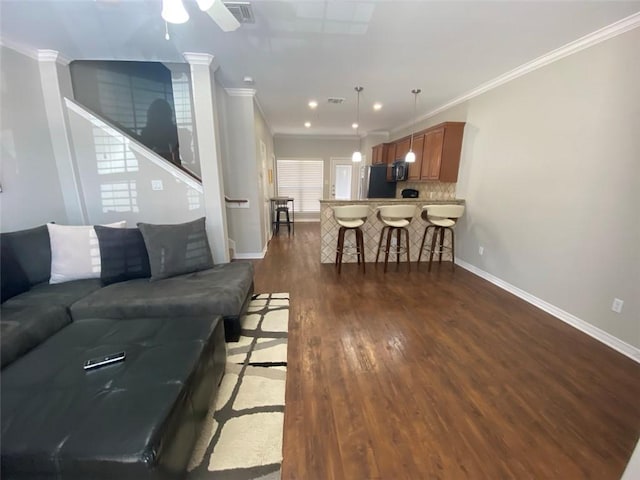 living room featuring ceiling fan, ornamental molding, and dark hardwood / wood-style floors