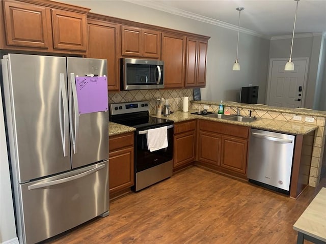 kitchen featuring decorative light fixtures, stainless steel appliances, tasteful backsplash, crown molding, and sink